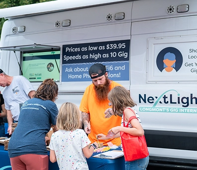 NextLight fiber internet van at Longmont community event promoting 10 Gig, Wi‑Fi 6, $39.95.