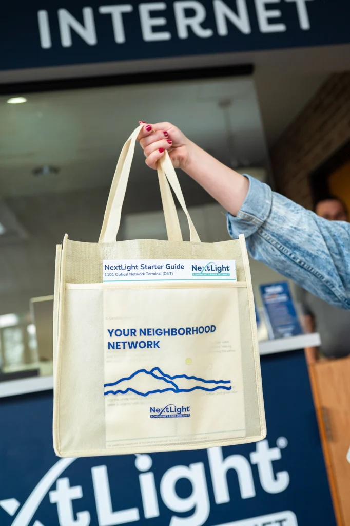 NextLight internet welcome kit canvas tote with mountain logo and Starter Guide.
